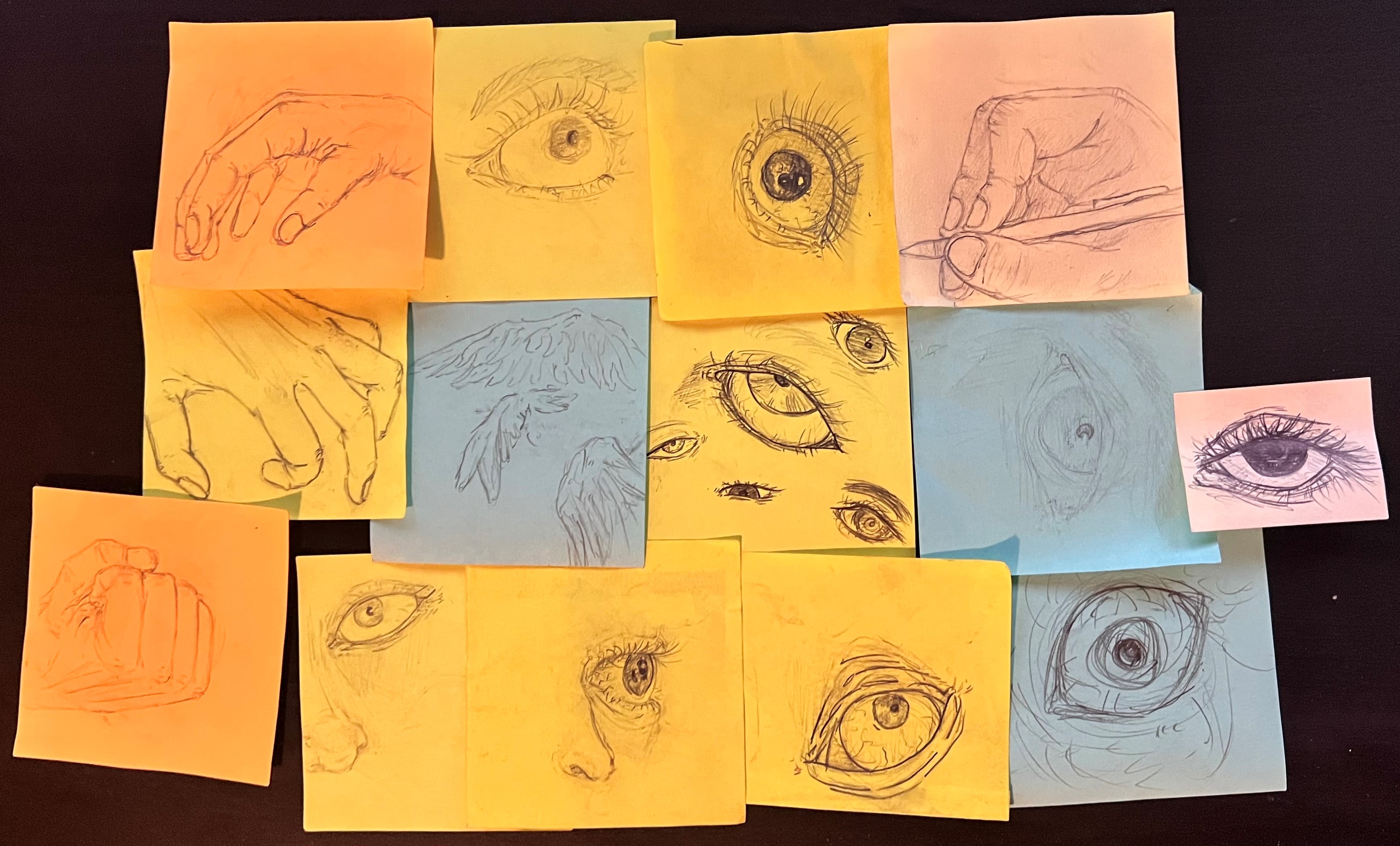 Many stickynote drawings of eyes, hands, and wings